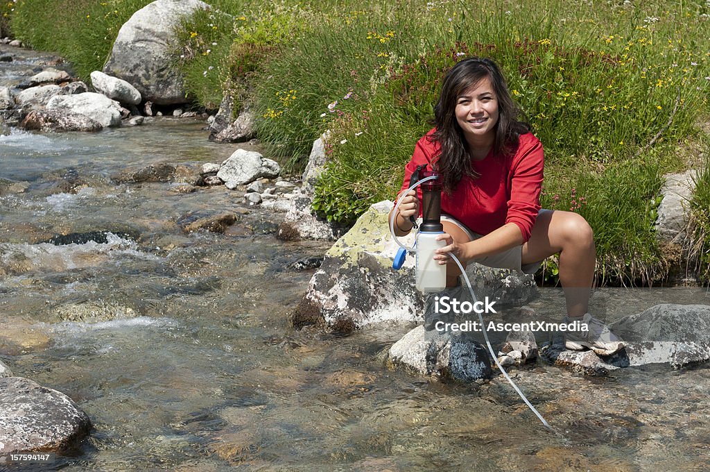 A camper refilling a water bottle from a portable filter