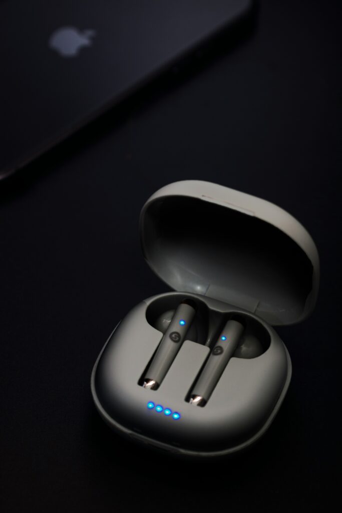 Wireless Bluetooth earbuds in a charging case on a desk