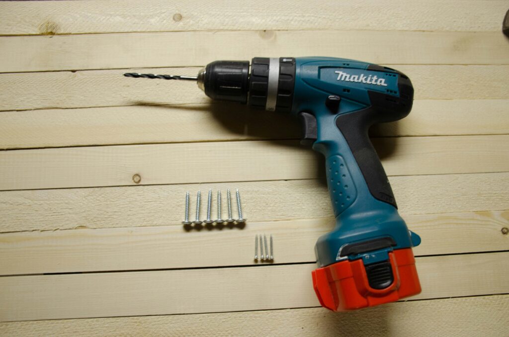 Cordless electric screwdriver with interchangeable bits on a workbench