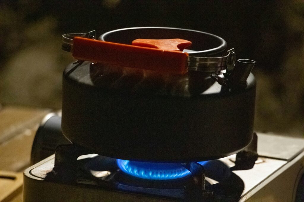 Compact portable grill set up at a campsite with food cooking