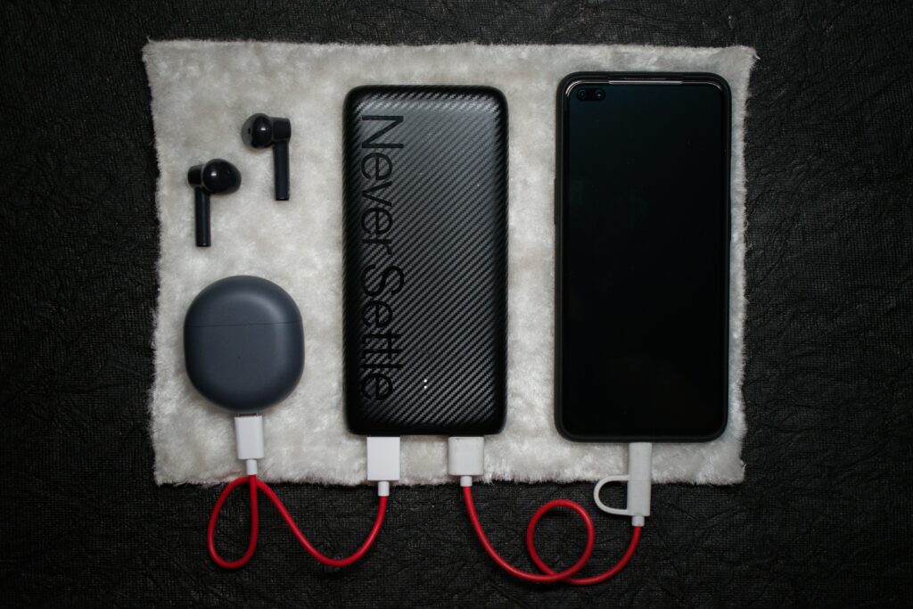 Slim power bank charging a smartphone via USB cable