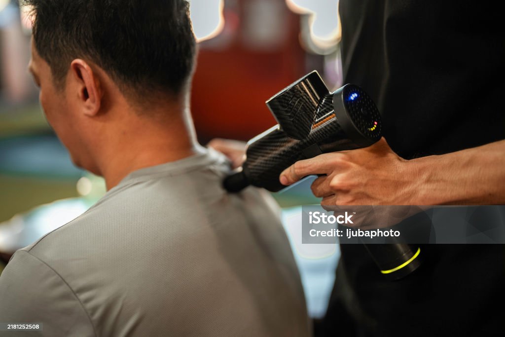 Electric massage pillow and handheld massage gun on a couch